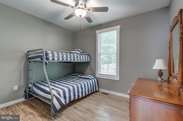 bedroom featuring visible vents, a ceiling fan, light wood-type flooring, and baseboards