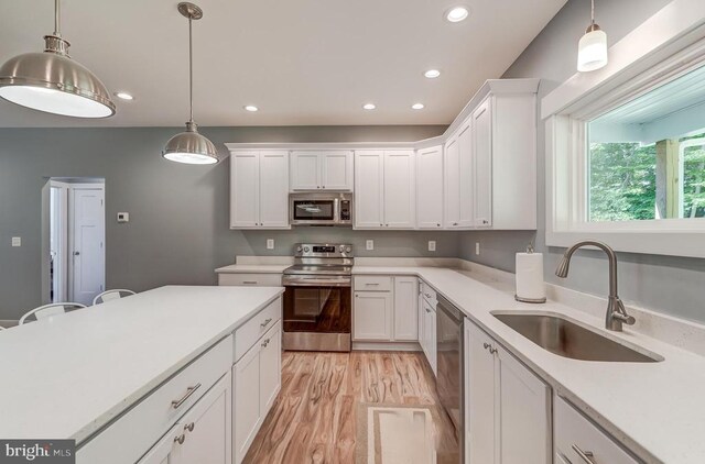 kitchen with a sink, white cabinetry, recessed lighting, appliances with stainless steel finishes, and light countertops