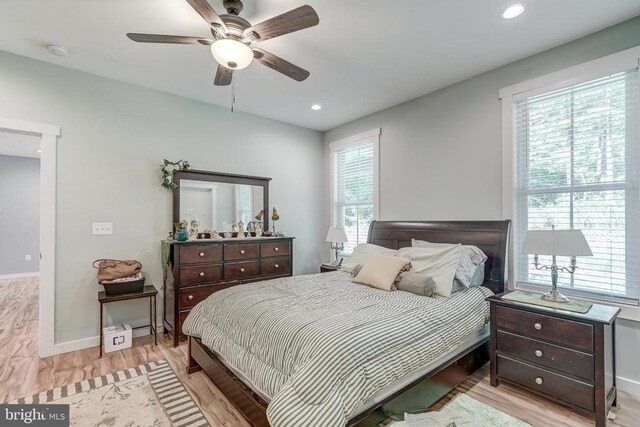 bedroom featuring recessed lighting, multiple windows, baseboards, and wood finished floors