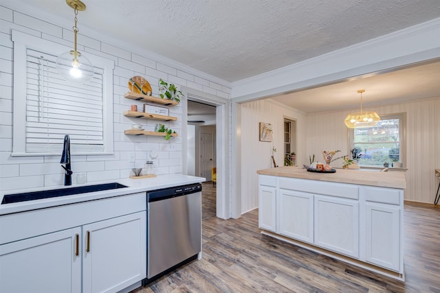 kitchen featuring hanging light fixtures, dishwasher, sink, and white cabinetry