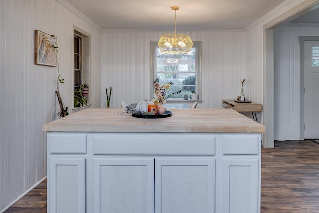 kitchen featuring pendant lighting, butcher block countertops, a center island, and white cabinets