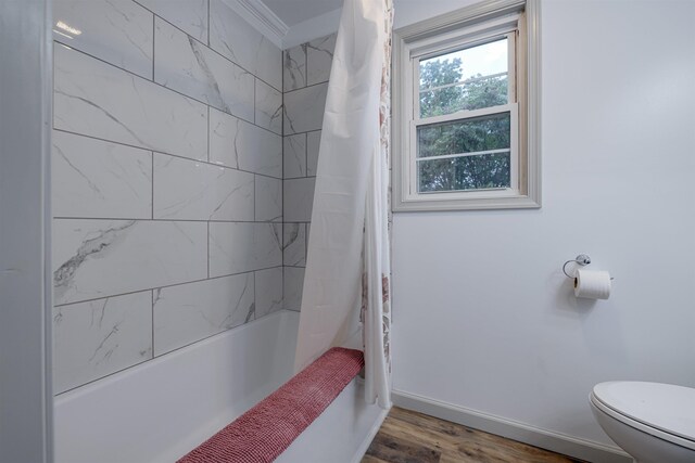 bathroom featuring wood-type flooring, toilet, and shower / bath combo