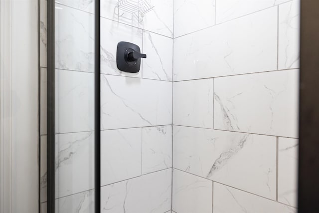 interior details featuring a tile shower