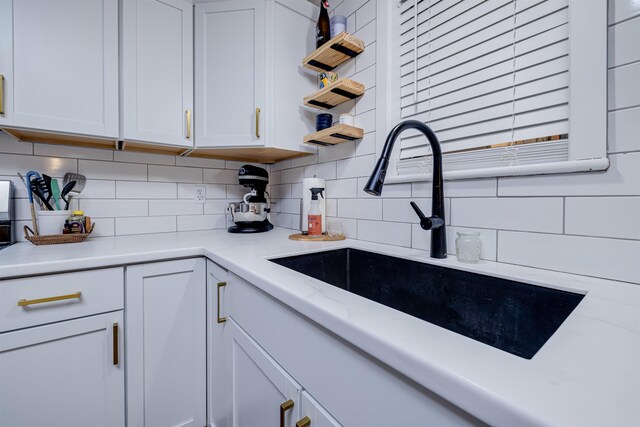 kitchen with white cabinetry, sink, and tasteful backsplash