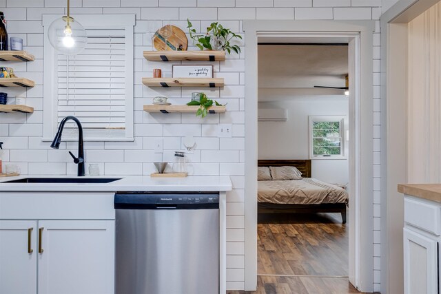 kitchen with stainless steel dishwasher, decorative light fixtures, sink, and white cabinets