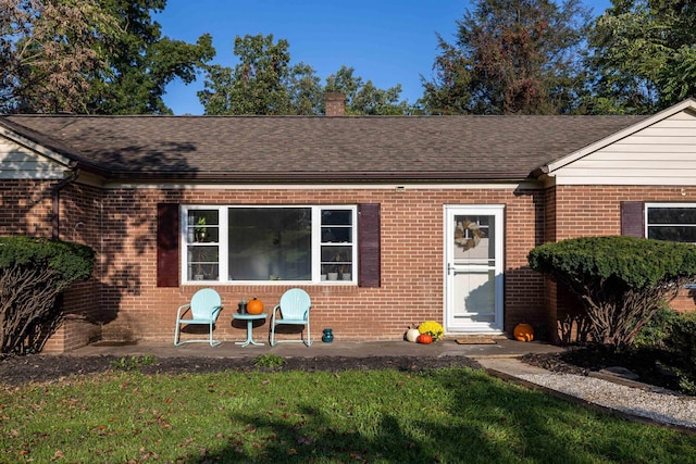 view of front of house with a front yard and a patio area