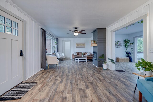 living room with ornamental molding, hardwood / wood-style floors, ceiling fan, and a fireplace