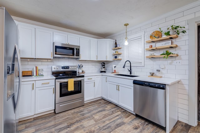 kitchen featuring dark hardwood / wood-style floors, decorative light fixtures, sink, white cabinets, and stainless steel appliances