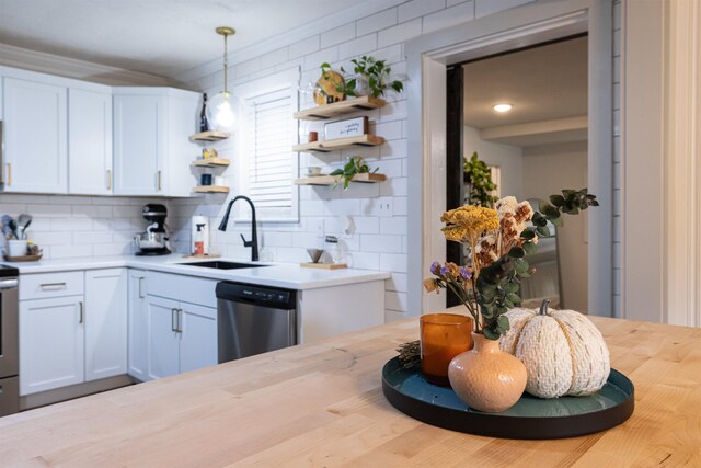 kitchen with pendant lighting, sink, dishwasher, backsplash, and white cabinets