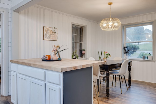 kitchen featuring hanging light fixtures, white cabinetry, a center island, and hardwood / wood-style floors