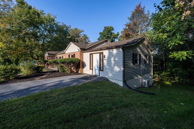 view of side of property featuring central AC and a lawn