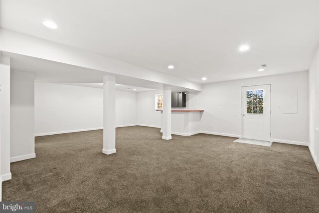 basement featuring dark colored carpet