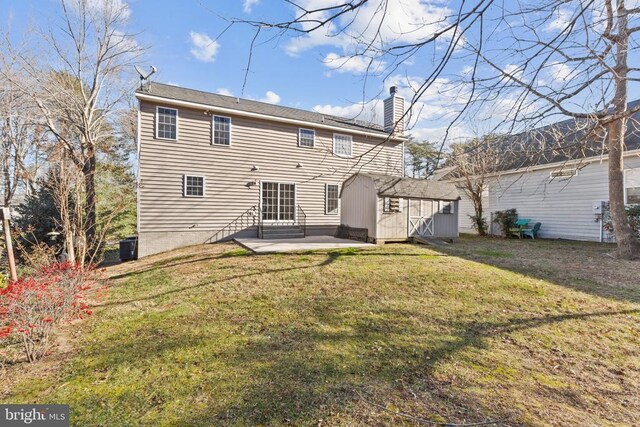 back of property featuring a storage shed, a yard, and a patio area