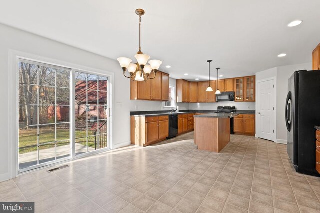 kitchen with pendant lighting, a notable chandelier, black appliances, and a kitchen island