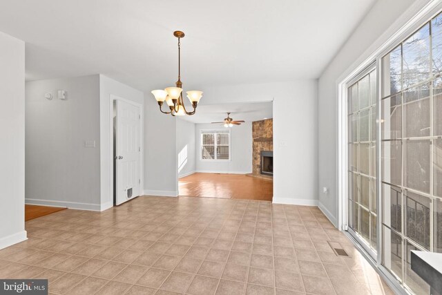 interior space with a fireplace and ceiling fan with notable chandelier