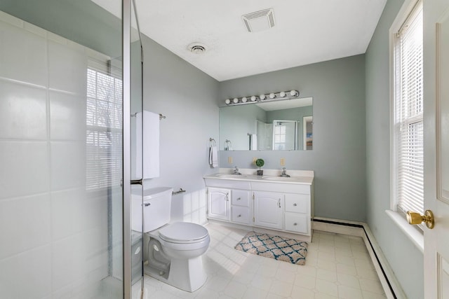 bathroom featuring vanity, a wealth of natural light, toilet, and baseboard heating