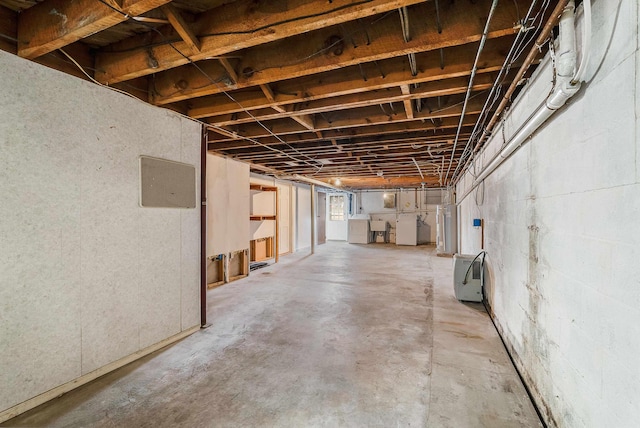 basement with water heater and washing machine and clothes dryer