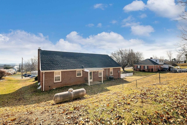 rear view of house with a lawn and central air condition unit