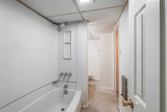 bathroom featuring a drop ceiling, shower / bathtub combination, and toilet