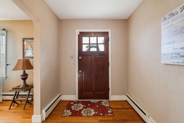 entryway with a baseboard heating unit and hardwood / wood-style flooring