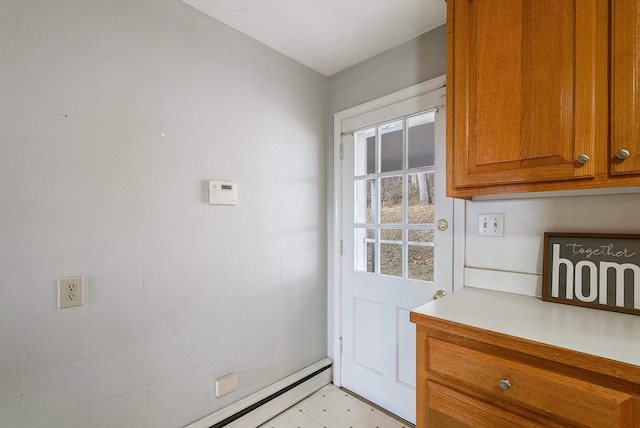 doorway to outside featuring a baseboard heating unit