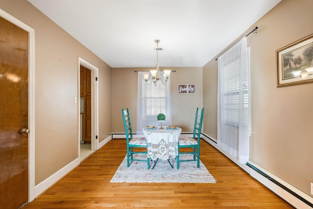 dining area with a notable chandelier, baseboard heating, and light hardwood / wood-style flooring