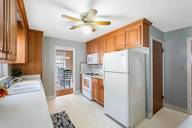 kitchen featuring ceiling fan with notable chandelier, white appliances, and sink