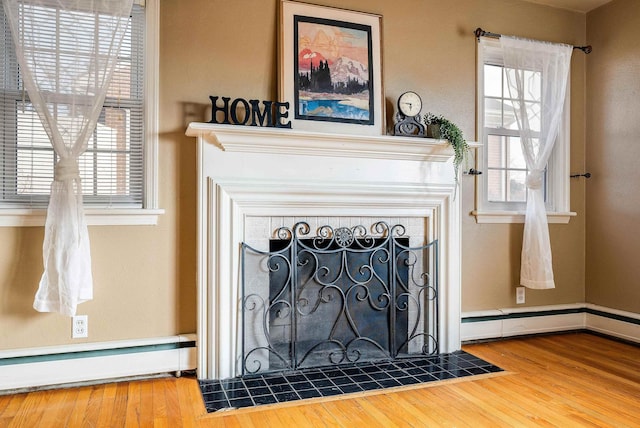 room details featuring hardwood / wood-style floors, a fireplace, and baseboard heating