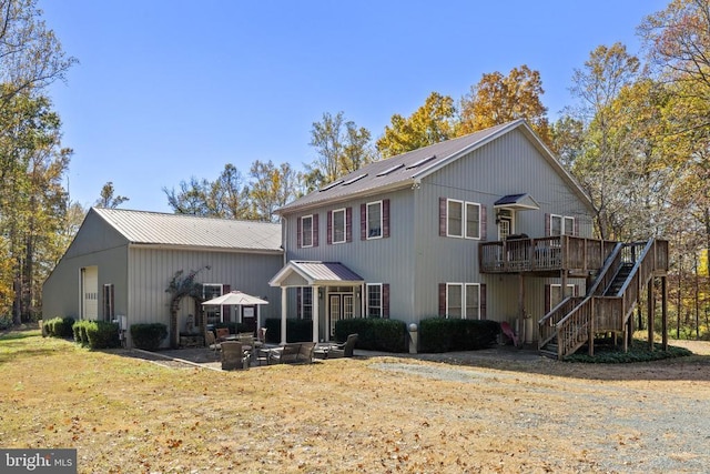 view of front of home featuring a wooden deck and a patio area