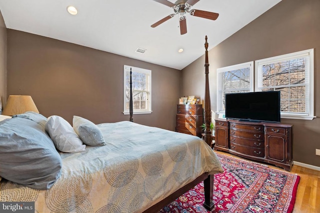 bedroom with light hardwood / wood-style flooring, vaulted ceiling, and ceiling fan