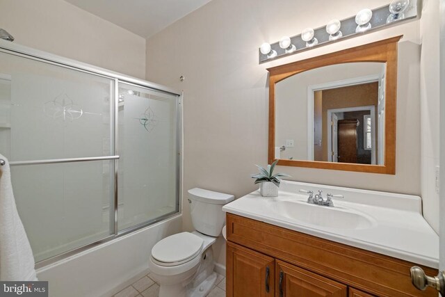 full bathroom featuring shower / bath combination with glass door, tile patterned floors, vanity, and toilet