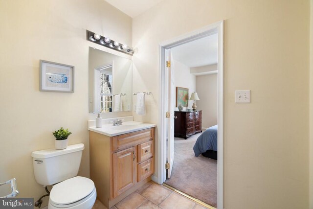 bathroom featuring vanity, tile patterned flooring, and toilet