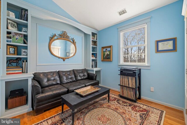 living room featuring lofted ceiling and hardwood / wood-style floors