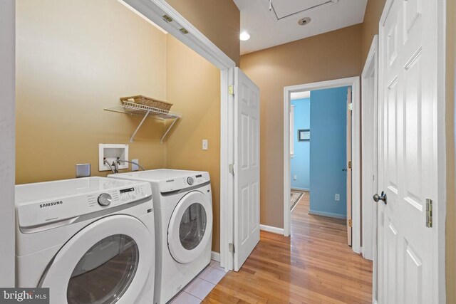 laundry room featuring separate washer and dryer and light wood-type flooring