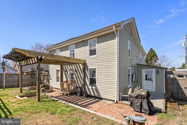 rear view of house featuring a patio, entry steps, a fenced backyard, and a pergola