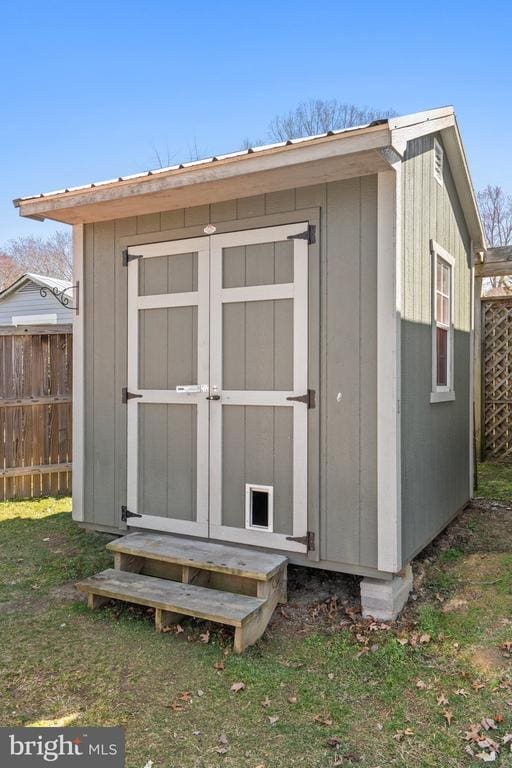 view of shed featuring fence