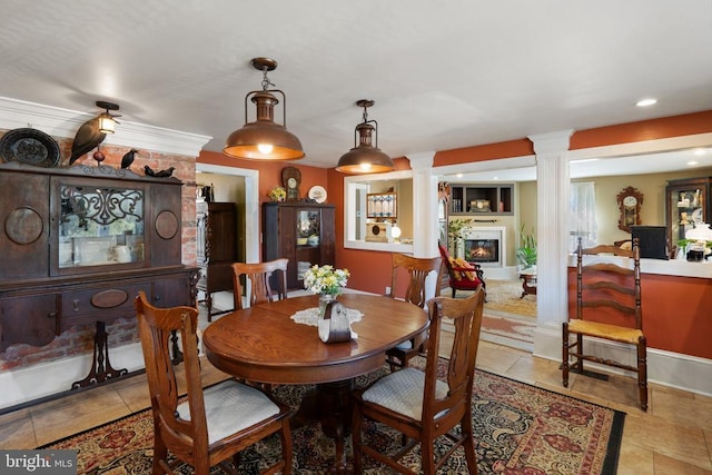 dining space with baseboards, ornate columns, light tile patterned flooring, recessed lighting, and a glass covered fireplace