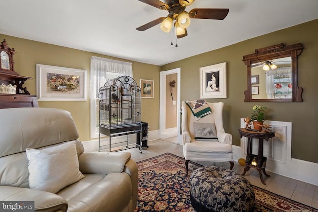 interior space with a ceiling fan, light wood-style floors, visible vents, and baseboards