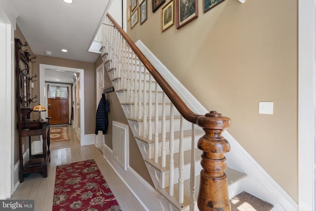 stairs featuring recessed lighting, visible vents, wood-type flooring, and baseboards