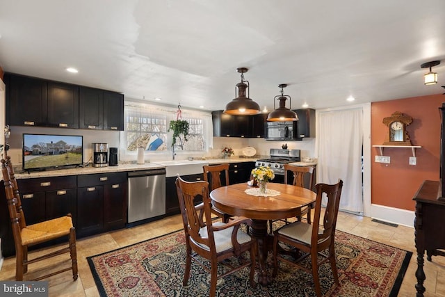 kitchen featuring dark cabinetry, stainless steel appliances, and light countertops