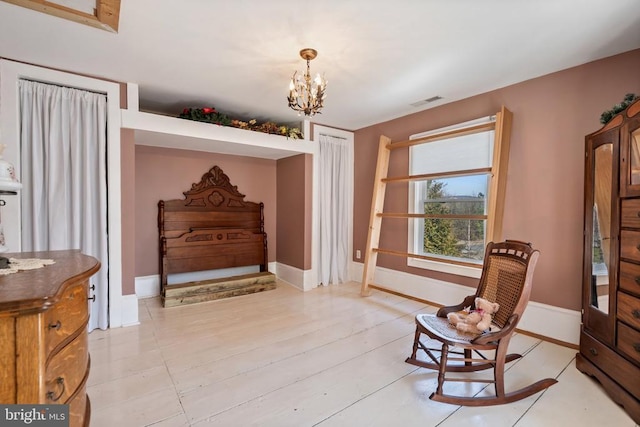 living area featuring baseboards, visible vents, and a chandelier