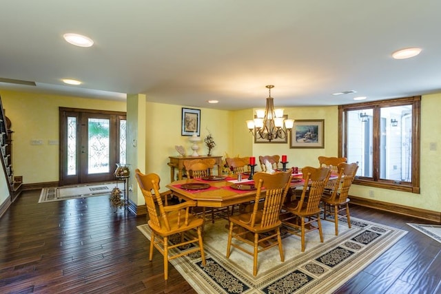 dining space with dark hardwood / wood-style flooring and a chandelier