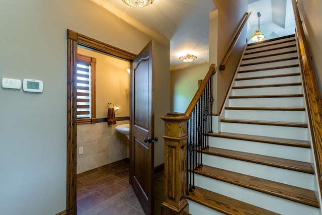 stairway featuring tile walls