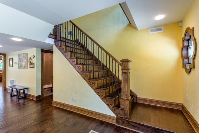 staircase with hardwood / wood-style floors