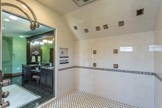 bathroom featuring tile patterned floors, vanity, and a tile shower