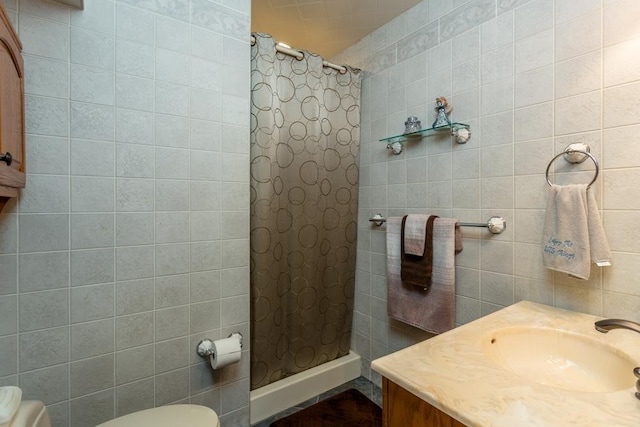 bathroom featuring tile walls, vanity, toilet, and walk in shower