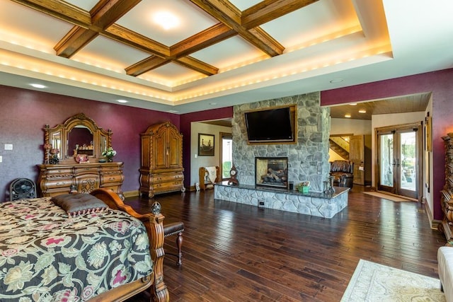 bedroom with dark wood-type flooring, coffered ceiling, and a fireplace