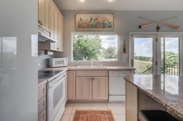 kitchen featuring light tile patterned flooring, white appliances, sink, and light stone counters