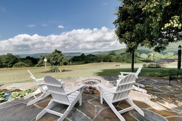 view of patio / terrace with a mountain view and an outdoor fire pit