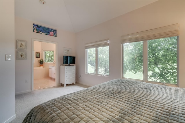 bedroom with light carpet, connected bathroom, and vaulted ceiling